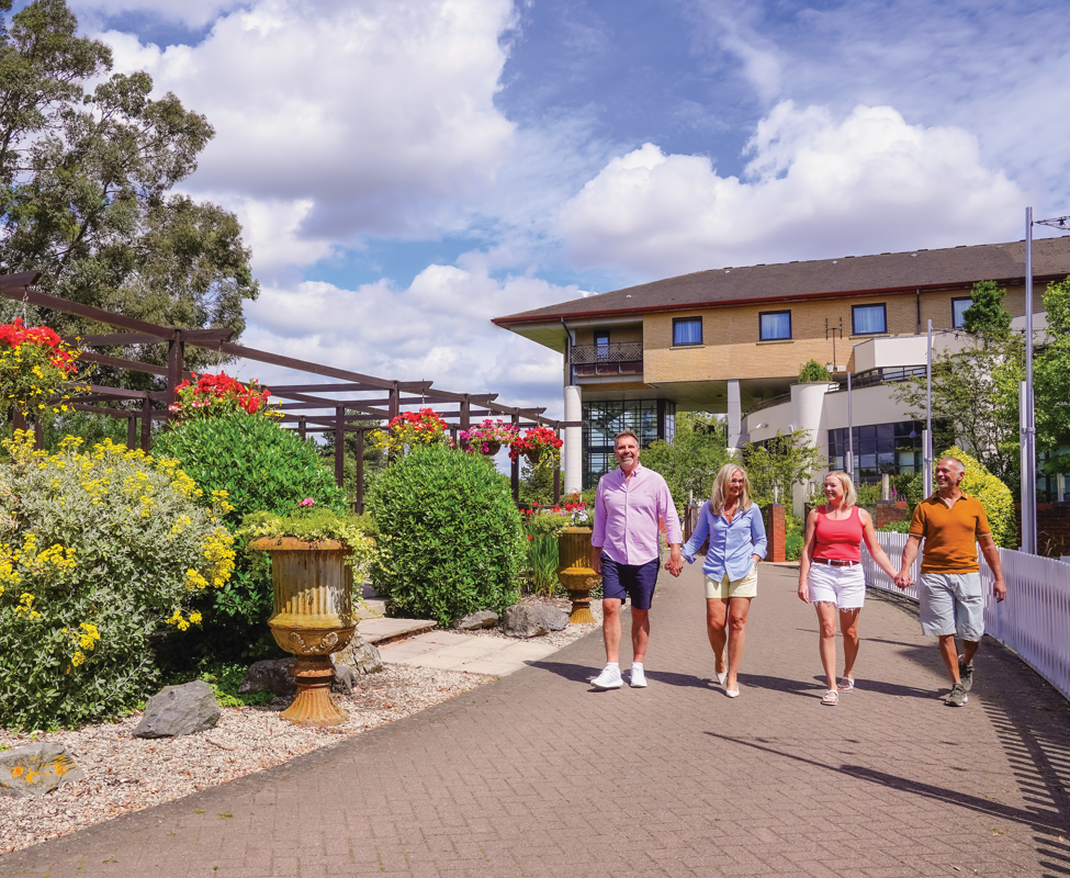 Couple models enjoying a sunny walk at Potters Resort’s landscaped gardens during a commercial shoot